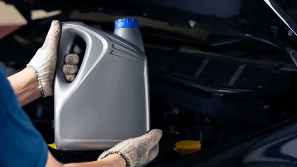 Car lubricant gallon or from gray bottle on engine background Oil change service