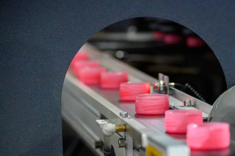 The row of pink plastic bottle caps